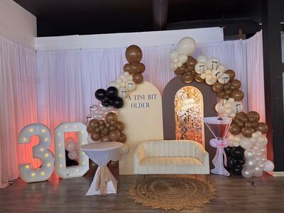 30th birthday A Tini Bit Older martini theme setup at The Prestige Venue with brown and white balloon arch
