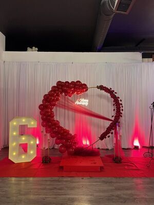 60th birthday celebration at The Prestige Venue with red heart balloon arch, marquee number 6, and white drapes