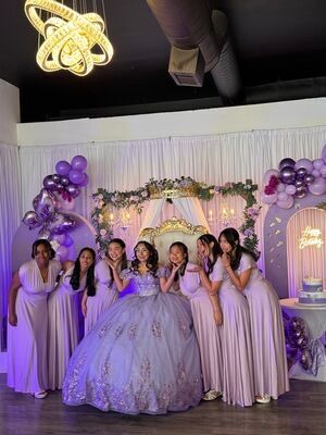 Quinceañera party inside The Prestige Venue with lavender theme, chandelier, and bridal party