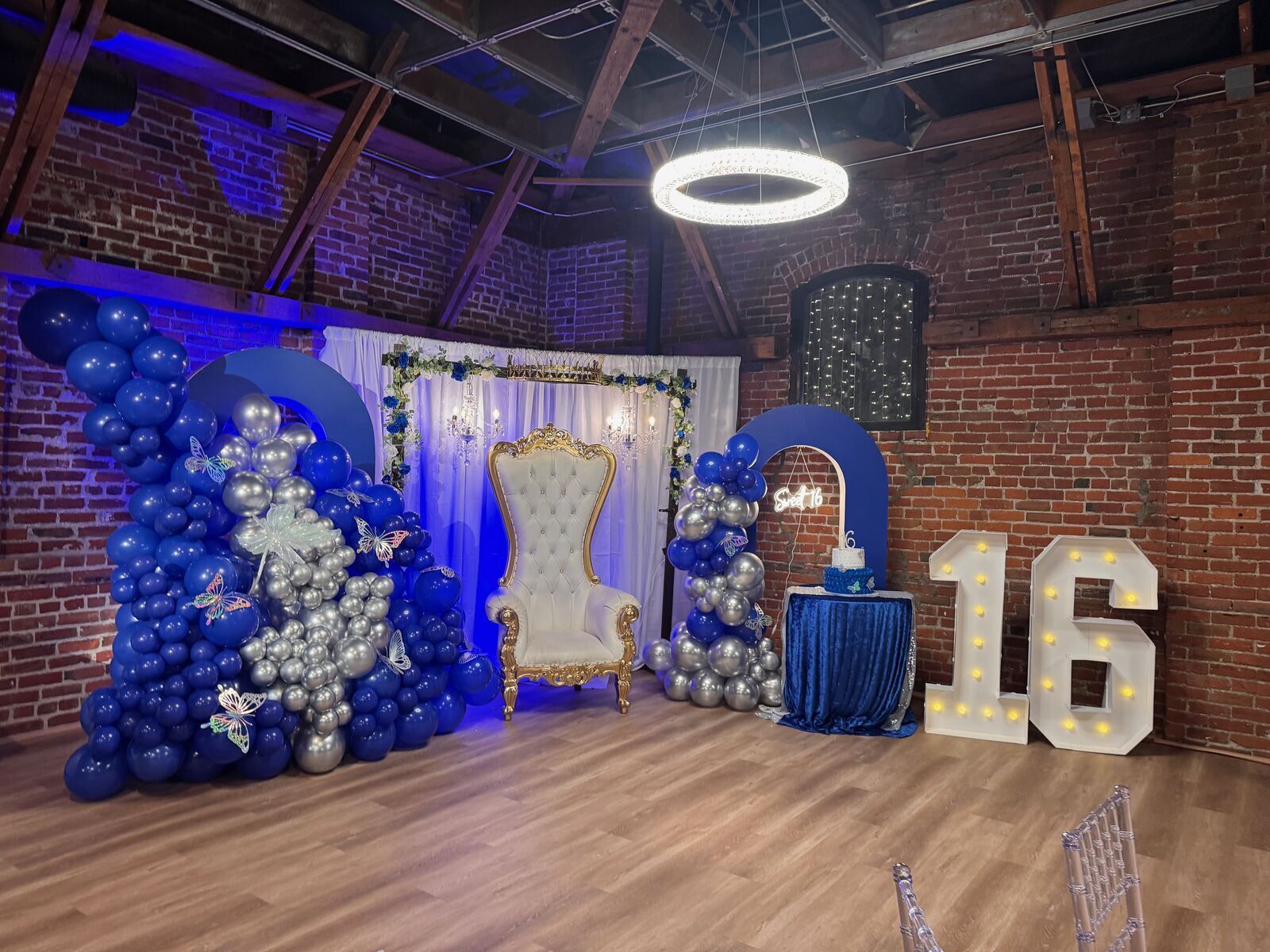 The Prestige Hall with exposed brick walls, elegant table settings, and pendant lighting