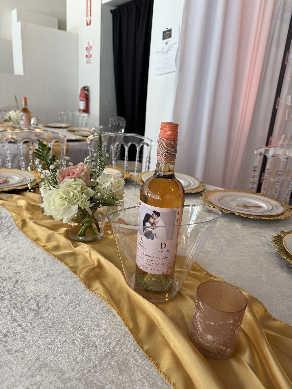Elegant wedding table setting with gold accents and wine bottles